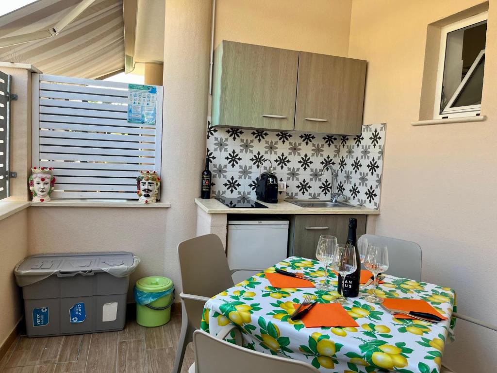 une petite cuisine avec une table et des chaises dans une pièce dans l'établissement Salsedine Tropea Capo Vaticano, à Santa Domenica
