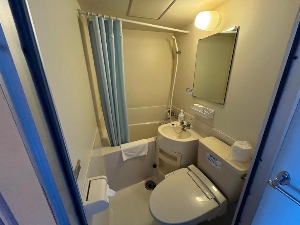 une petite salle de bain avec toilettes et lavabo dans l'établissement Hotel Shiretoko, à Shari