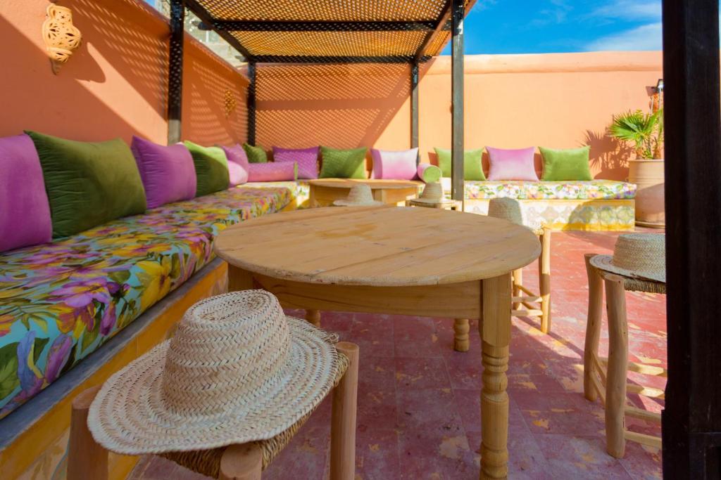 une personne portant un chapeau assise à une table dans l'établissement Riad Ikalimo 2, à Marrakech