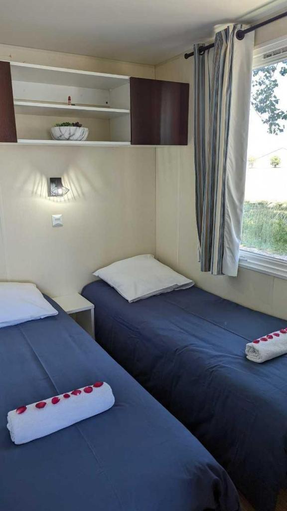 deux lits dans une petite pièce avec une fenêtre dans l'établissement Cottage flottant terrasse gamme supérieure option jacuzzi proche Dijon, à Ouges