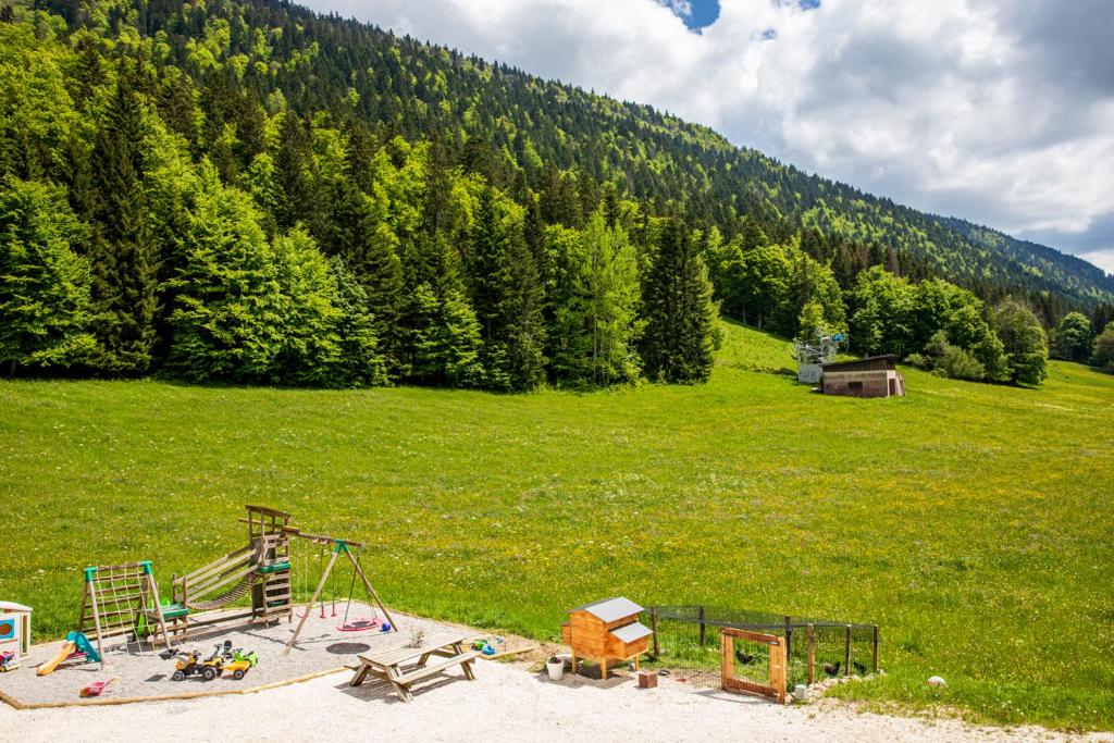 une aire de jeux dans un champ avec une colline et des arbres dans l'établissement Studio La Résilience, au pied des pistes à Autrans, à Autrans 29 autres photos