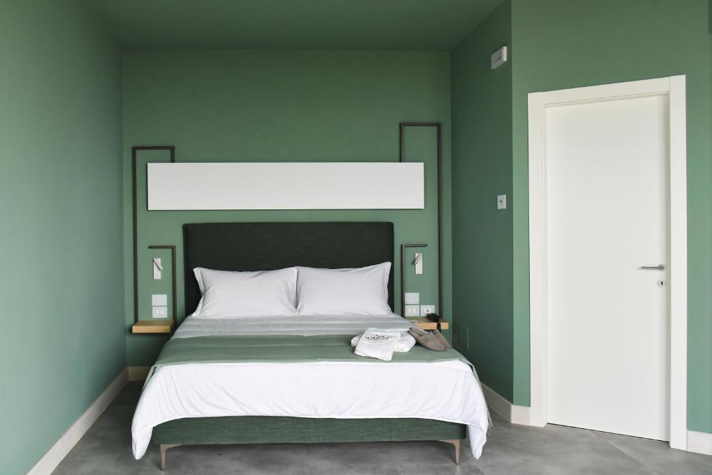 une chambre avec un grand lit aux murs verts dans l'établissement Maiorano Boutique Hotel, à Manfredonia