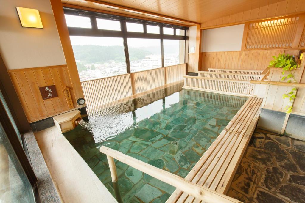 - une piscine d'eau dans une pièce avec bancs dans l'établissement Takayama Ouan, à Takayama
