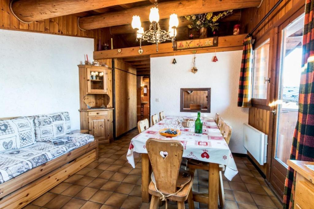 une salle à manger avec une table et un canapé dans l'établissement Le Rhododendron, à La Plagne Tarentaise