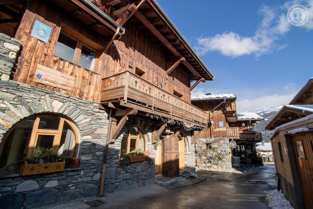 un grand bâtiment en bois avec un balcon. dans l'établissement L'epilobe, à La Plagne Tarentaise