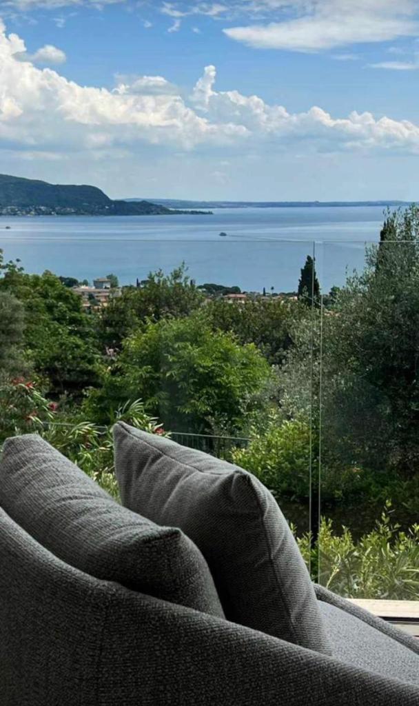 un canapé assis devant une vue sur l'eau dans l'établissement Villa Diamante del Garda & Spa, à Toscolano Maderno