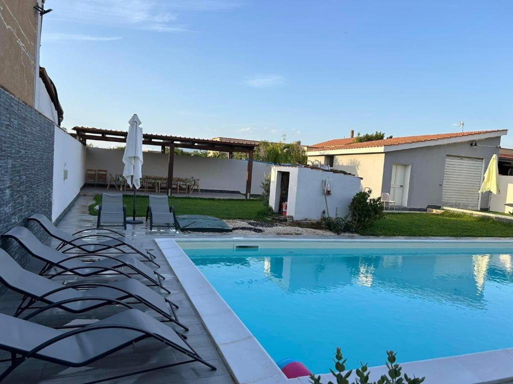 - une piscine dans une cour avec des chaises et un parasol dans l'établissement Lemon Gold, à Locogrande