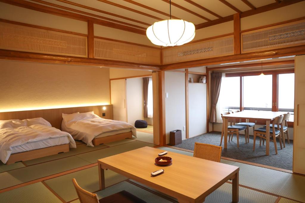 une chambre avec un lit et une table et une salle à manger dans l'établissement Chigira Jinsentei, à Shibukawa