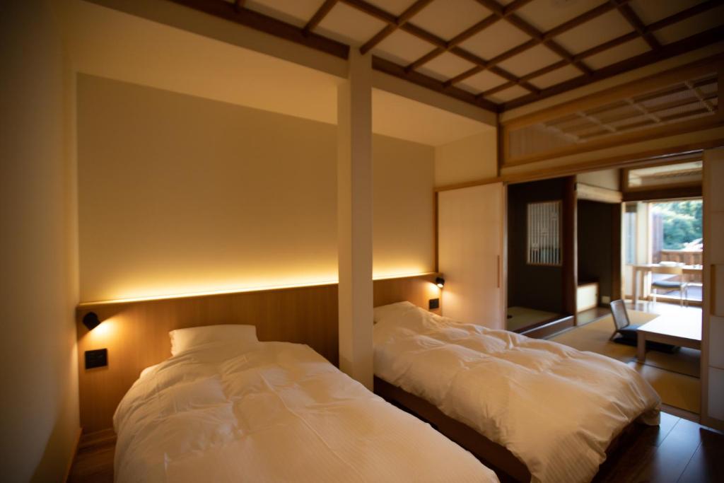 une chambre avec deux lits dans une pièce dans l'établissement Chigira Jinsentei, à Shibukawa 29 autres photos