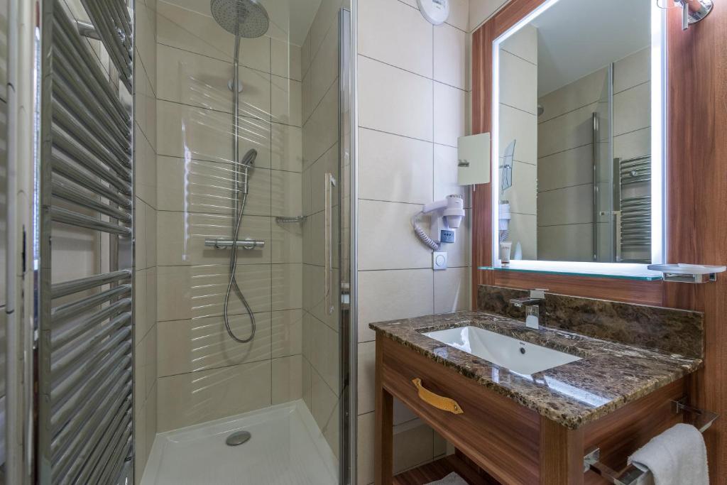 une salle de bain avec un lavabo et une douche dans l'établissement Appart'Hotel Prestige Odalys Eden, à Arc 1800