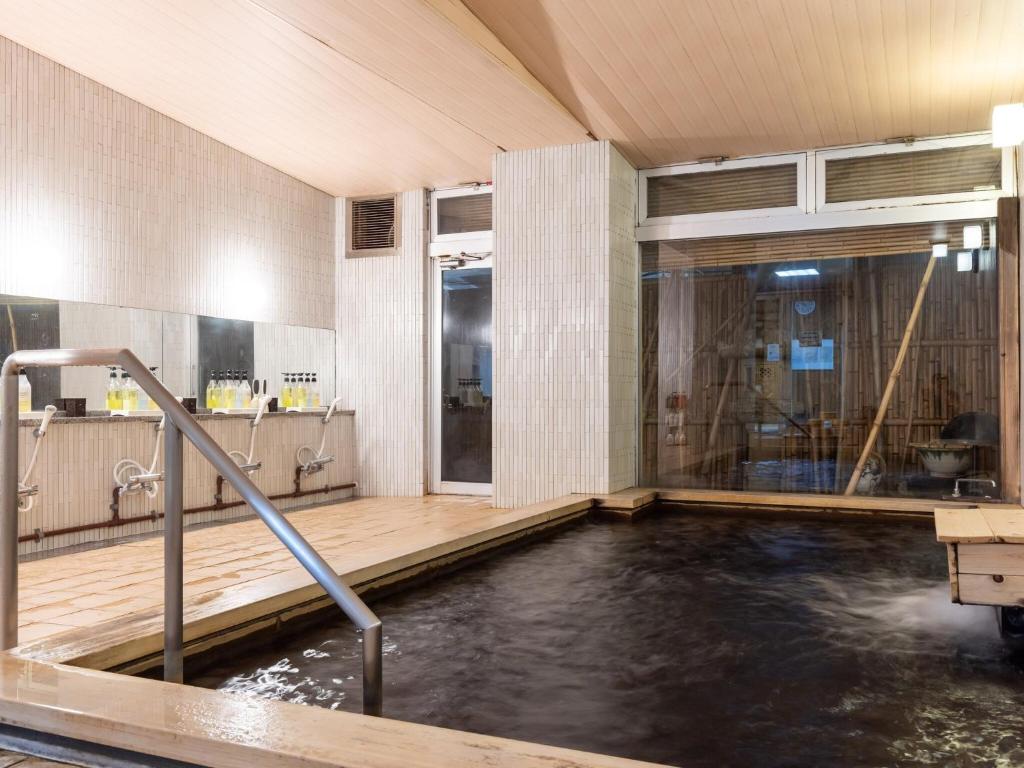 une piscine d'eau dans une pièce avec douche dans l'établissement Kiso Mikawaya, à Kiso