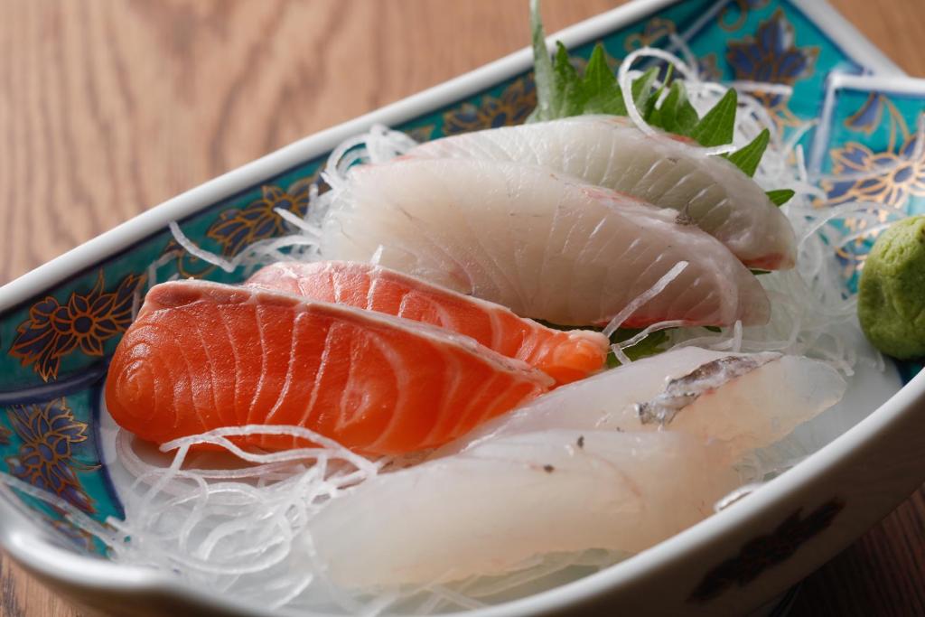 une assiette de nourriture avec différents types de poissons dans l'établissement Tsuruya Ryokan, à Toyooka