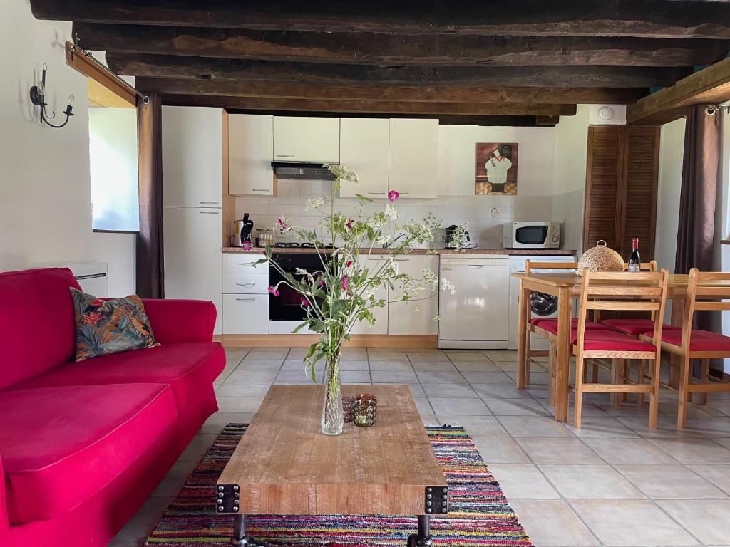 un salon avec un canapé rouge et une table dans l'établissement gites le ciel clair, à Mortroux