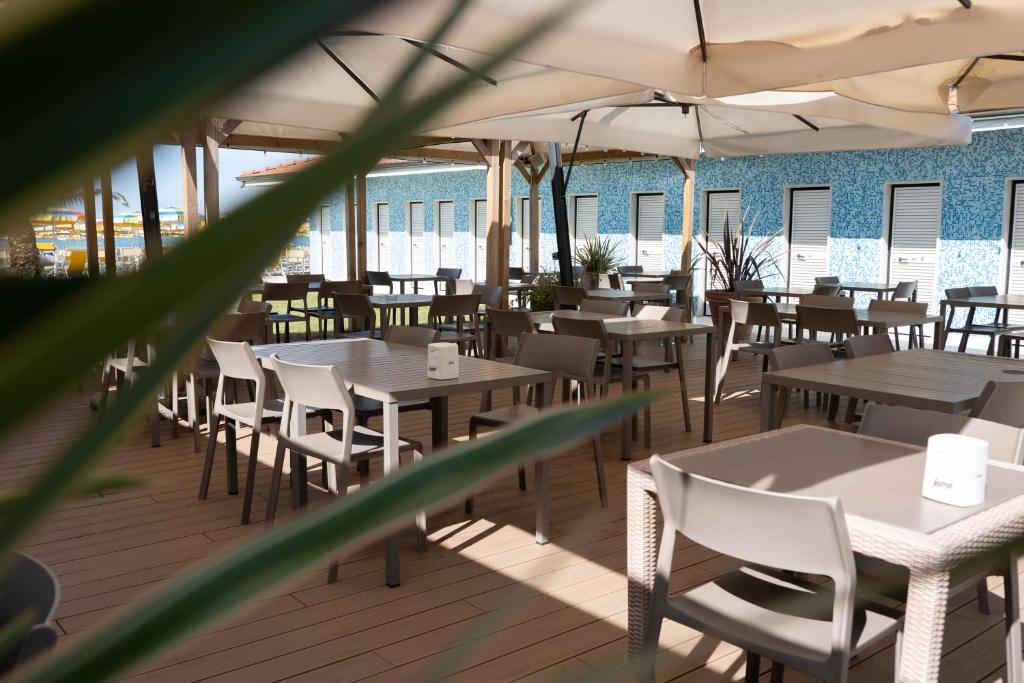 un restaurant avec des tables, des chaises et des parasols dans l'établissement Bagno Lunezia, à Marina di Carrara