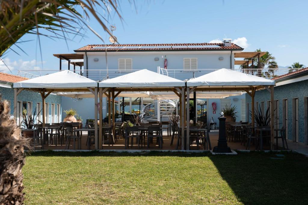 un patio avec des tables et des chaises sous des parasols dans l'établissement Bagno Lunezia, à Marina di Carrara 17 autres photos