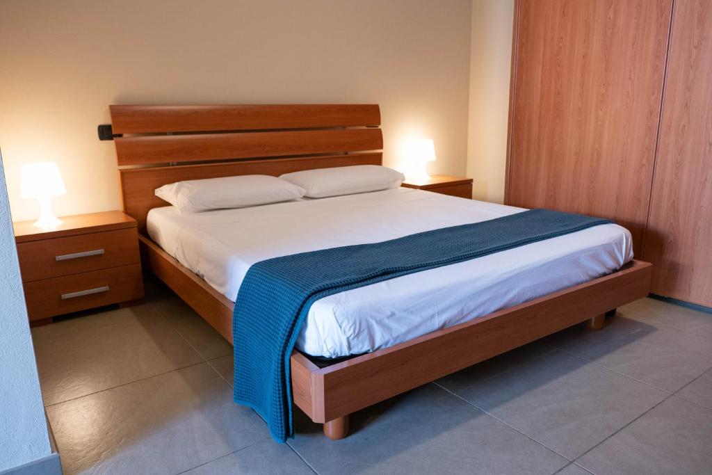 - une chambre avec un lit, 2 tables de chevet et 2 lampes dans l'établissement Bagno Lunezia, à Marina di Carrara