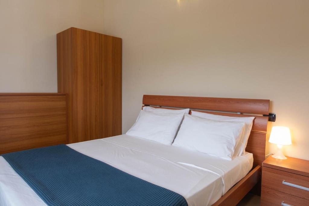 une chambre avec un lit avec une tête de lit en bois dans l'établissement Bagno Lunezia, à Marina di Carrara