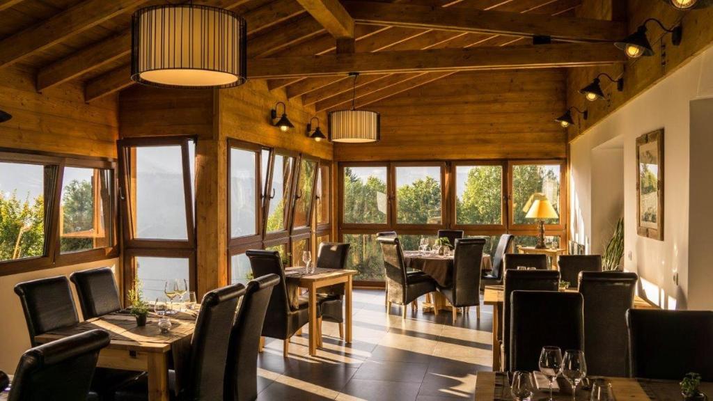 une salle à manger avec tables, chaises et fenêtres dans l'établissement Le Caprice Des Neiges, à Crest-Voland