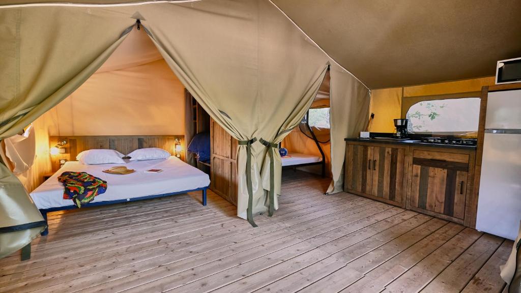 une chambre avec un lit dans une tente dans l'établissement Domaine Les Chênes Blancs, à Saint-Saturnin-lès-Apt