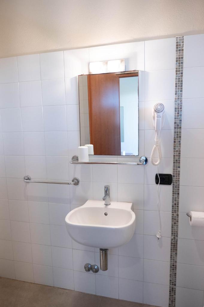une salle de bain avec un lavabo et un miroir dans l'établissement Bagno Lunezia, à Marina di Carrara