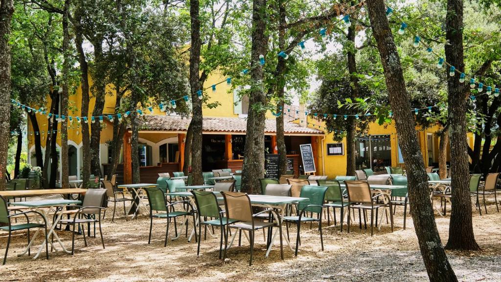 un groupe de tables et de chaises devant un bâtiment dans l'établissement Domaine Les Chênes Blancs, à Saint-Saturnin-lès-Apt