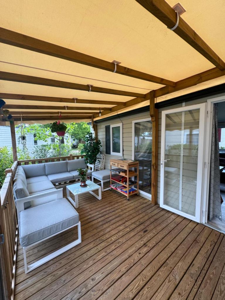 un patio avec un canapé et des chaises sur une terrasse dans l'établissement Mobil-Home, à Lège-Cap-Ferret