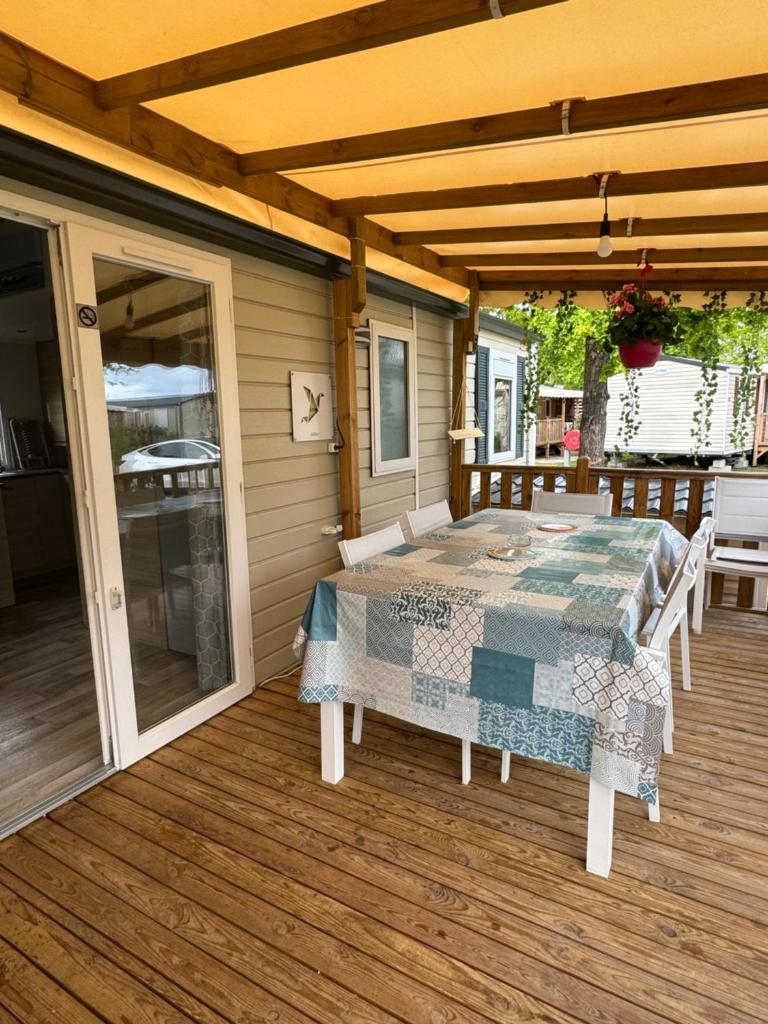 un patio avec une table et des chaises sur une terrasse dans l'établissement Mobil-Home, à Lège-Cap-Ferret