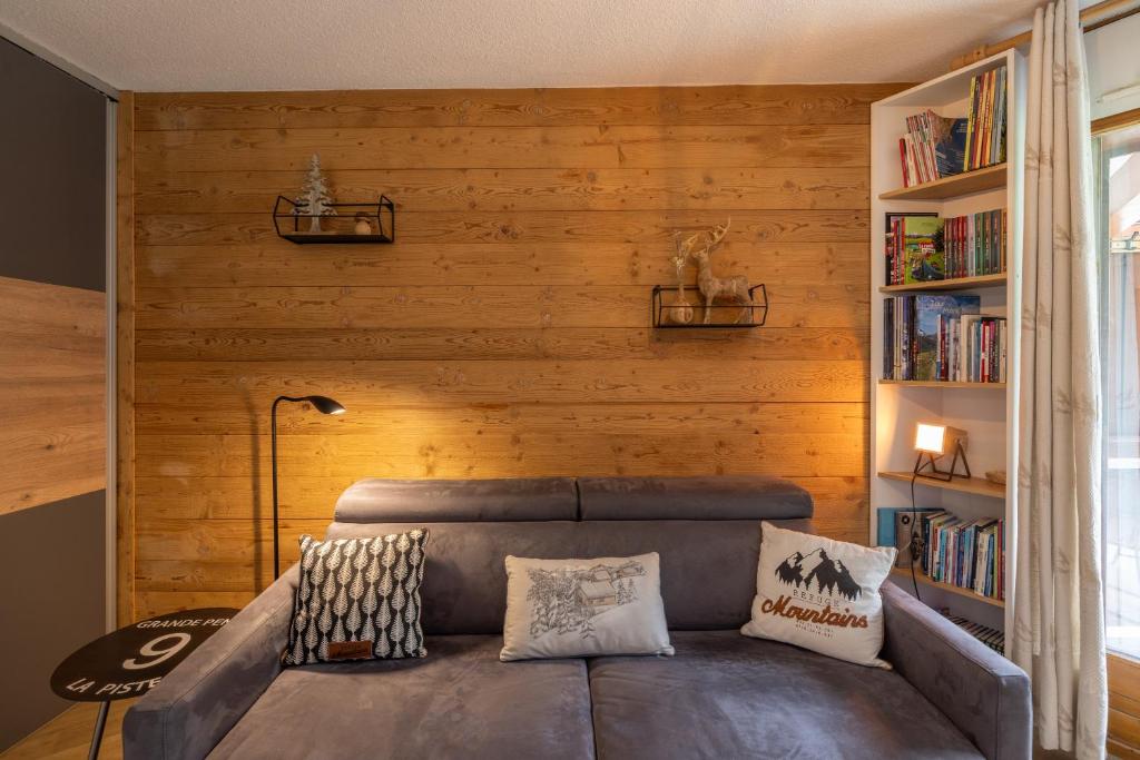 - un salon avec un canapé et des étagères dans l'établissement Studio haut de gamme Contamines, aux Contamines-Montjoie