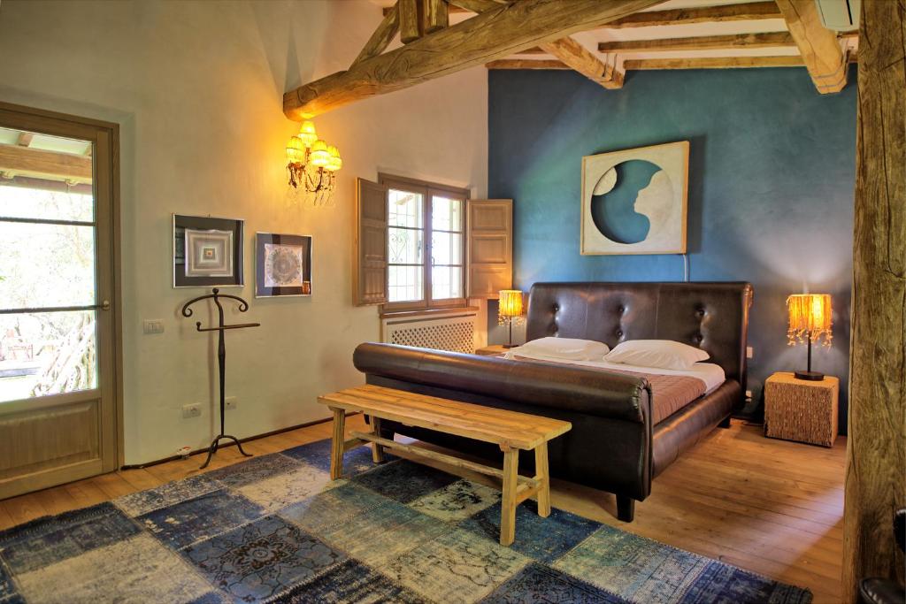 - une chambre avec un lit et un banc dans l'établissement Villa Oliveta by PosarelliVillas, à Santa Lucia