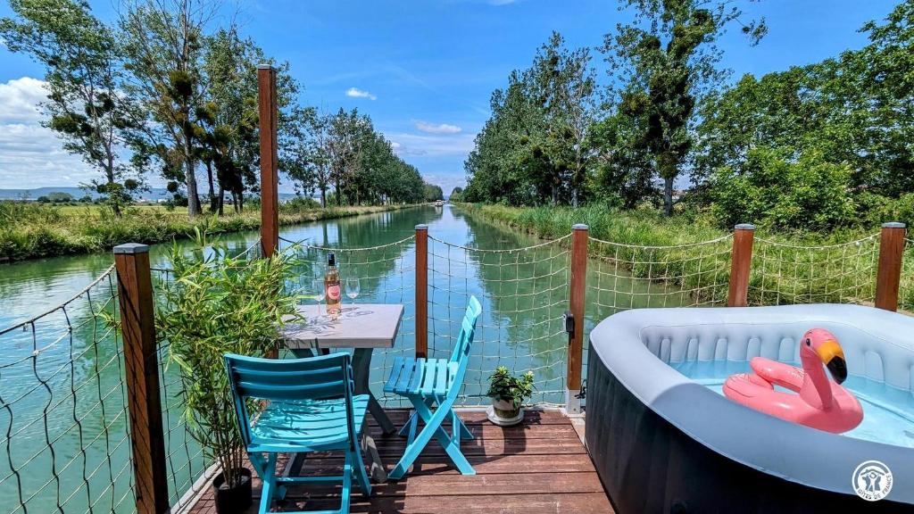 une baignoire posée sur une terrasse à côté d'une table et de chaises dans l'établissement Cottage flottant terrasse jacuzzi option aux Portes de Dijon, à Ouges 13 autres photos
