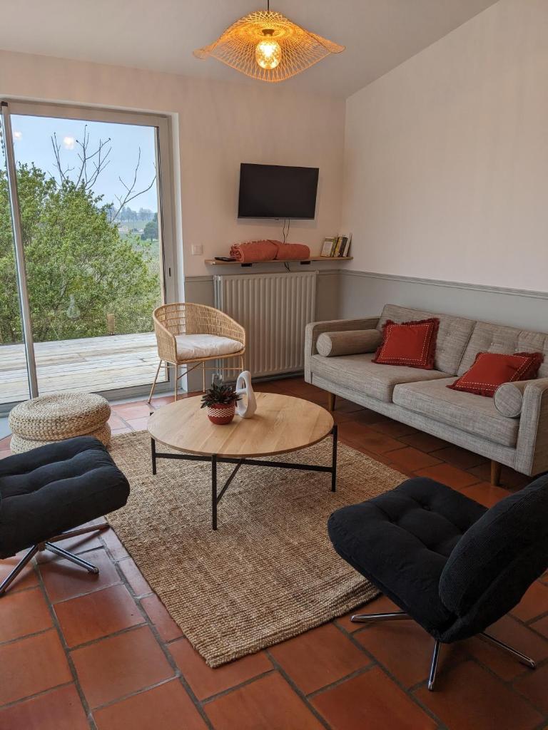 un salon avec un canapé et une table dans l'établissement La maison des coteaux - Gîte avec vue d'exception, à Fronsac 13 autres photos