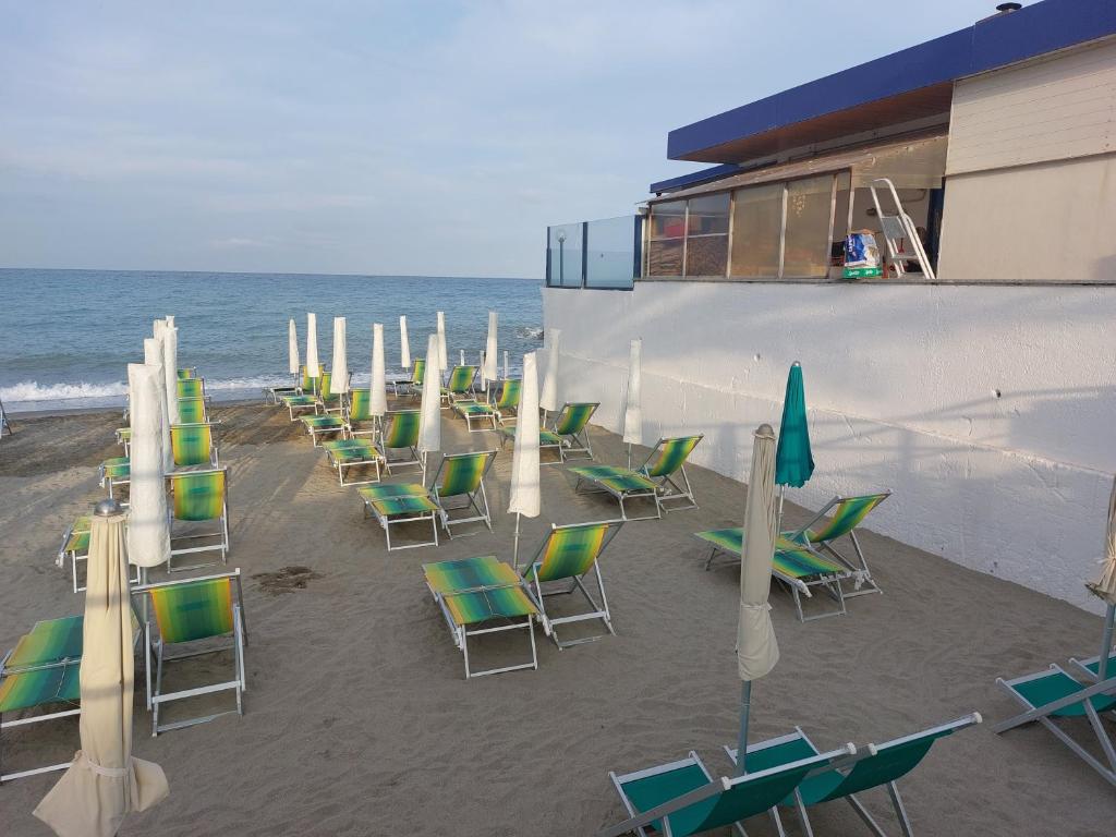 une rangée de chaises et de parasols sur une plage dans l'établissement Residence Aurora Wellness & Spa, à Albenga