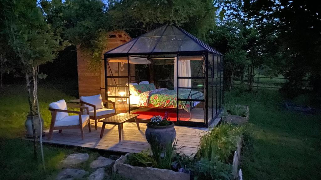 un gazebo avec un lit et un lit dans l'établissement Le jardin secret, à Semur-en-Auxois