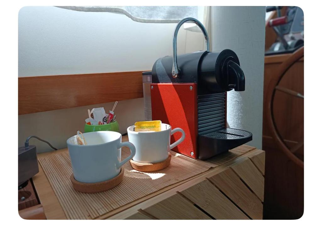 2 tasses à café assises sur une table à côté d'un grille-pain dans l'établissement Nuit insolite et cocon, à Valence