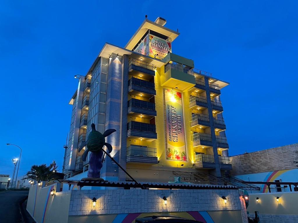 un homme debout sur un tuyau devant un bâtiment dans l'établissement HOTEL ATLANTIS NUMAZU -Adult Only, à Ashitaka