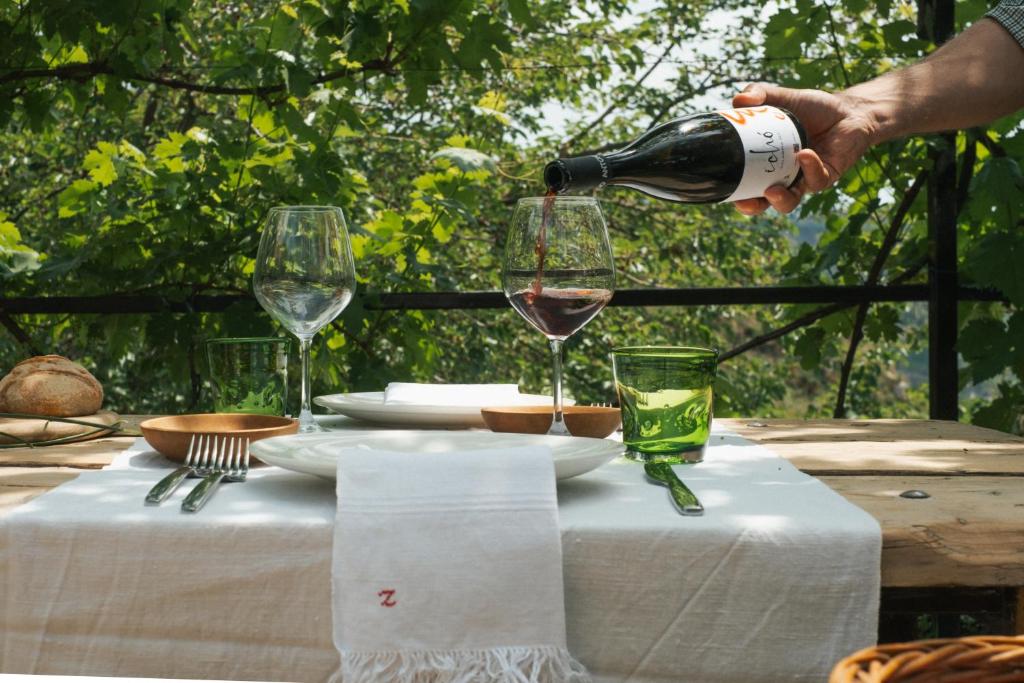 une personne versant un verre de vin sur une table dans l'établissement Locanda degli Ulivi, à Mammola