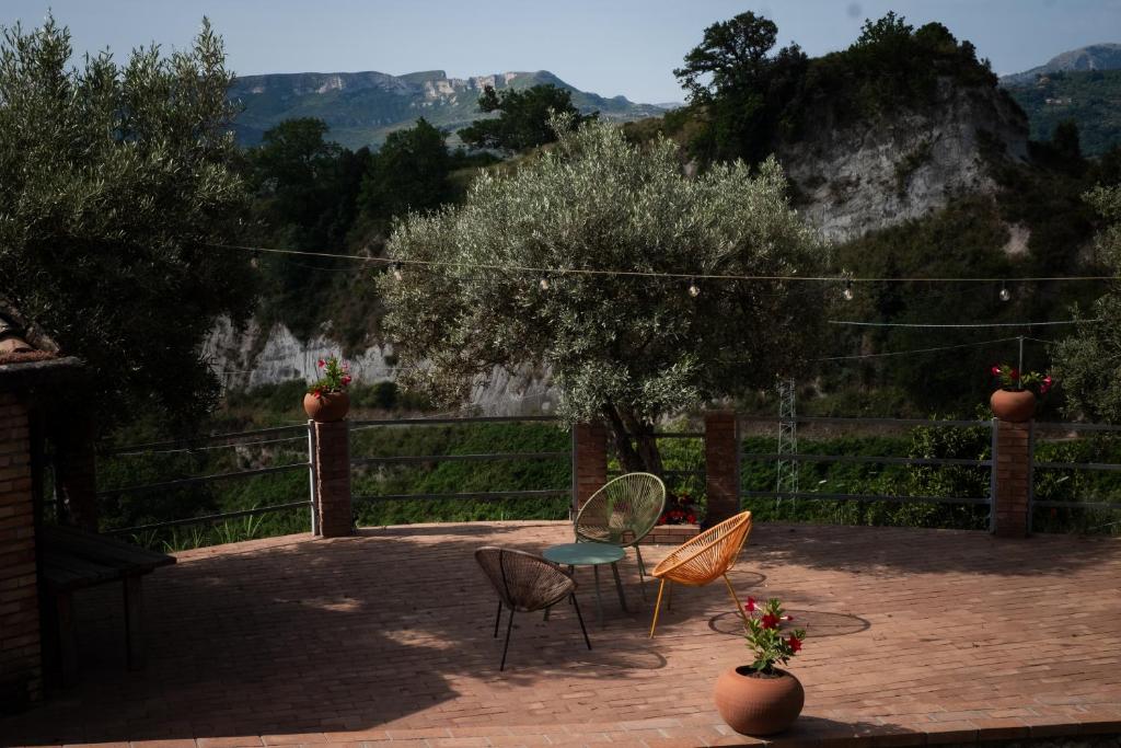un groupe de chaises et une table sur une terrasse dans l'établissement Locanda degli Ulivi, à Mammola