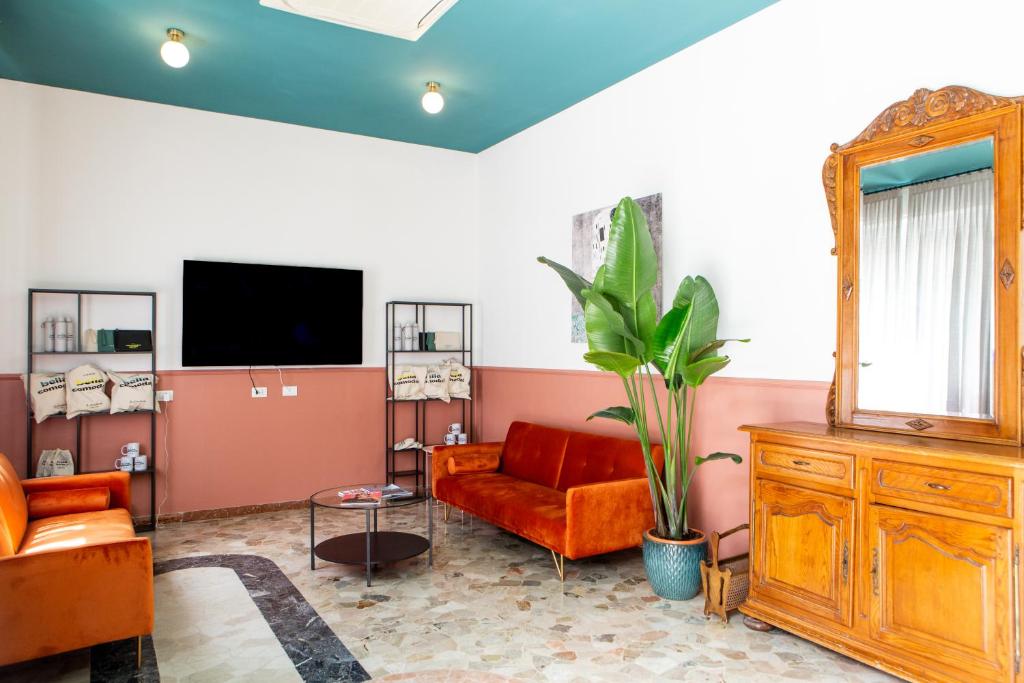 un salon avec un canapé rouge et un miroir dans l'établissement Hotel Belvedere Rimini, à Rimini