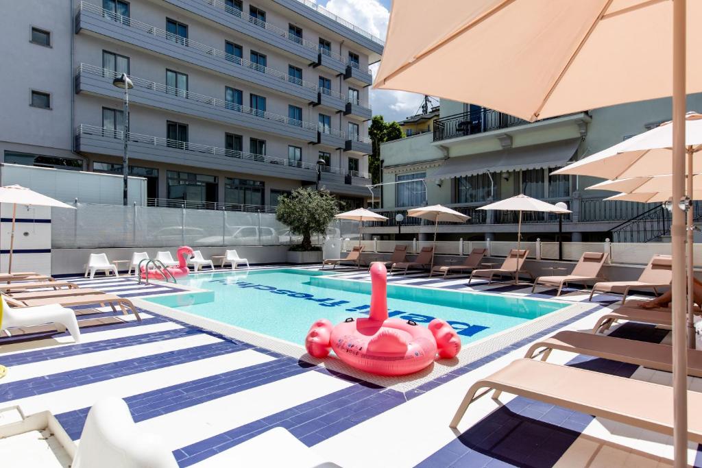 - une piscine avec des chaises et un jouet gonflable dans l'établissement Hotel Belvedere Rimini, à Rimini