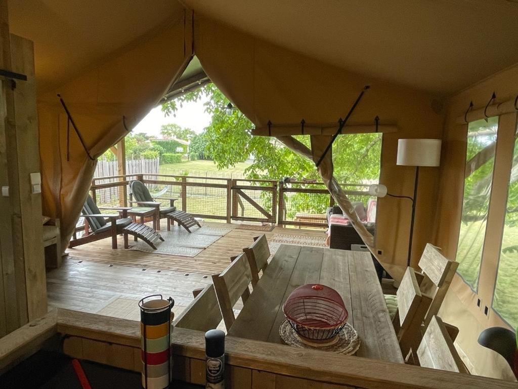 une vue d'une terrasse en bois avec une table dans l'établissement LODGE Champêtre Glamping, à Chadenac