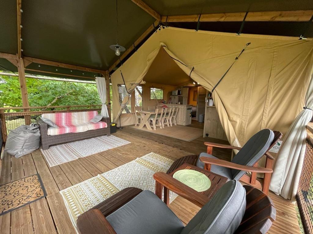 une tente avec des chaises et une table. dans l'établissement LODGE Champêtre Glamping, à Chadenac