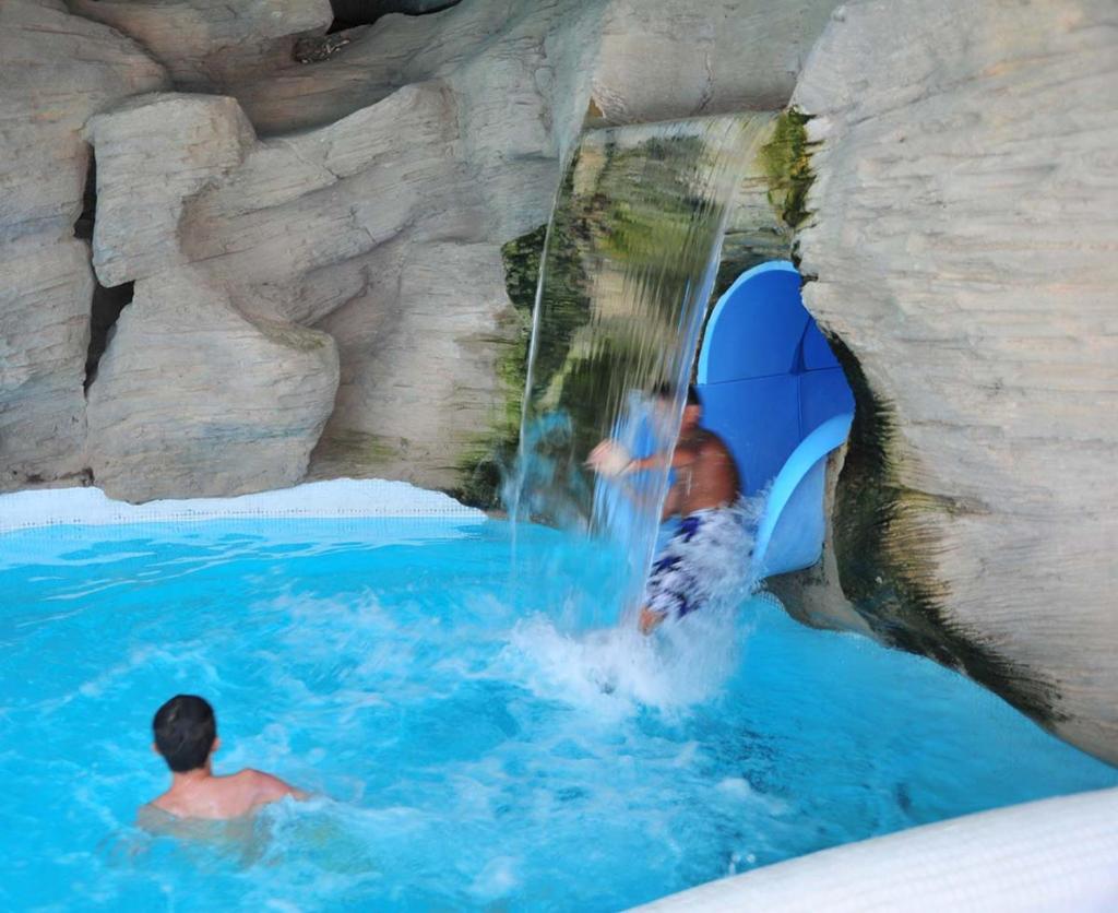 - un homme à bord d'un toboggan dans un parc aquatique dans l'établissement Mobile Home avec piscine dans Camping calme Proche plage, à Saint-Hilaire-de-Riez 6 autres photos