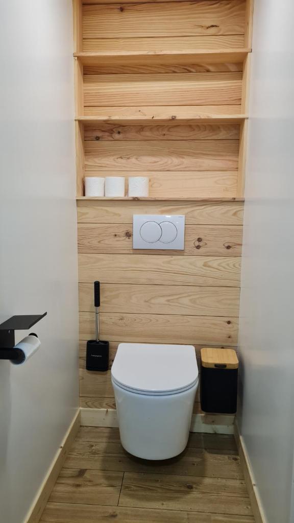 La salle de bains est pourvue de toilettes blanches et de murs en bois. dans l'établissement La Duchère 6 personnes Le Plan La Giettaz, à La Giettaz 37 autres photos