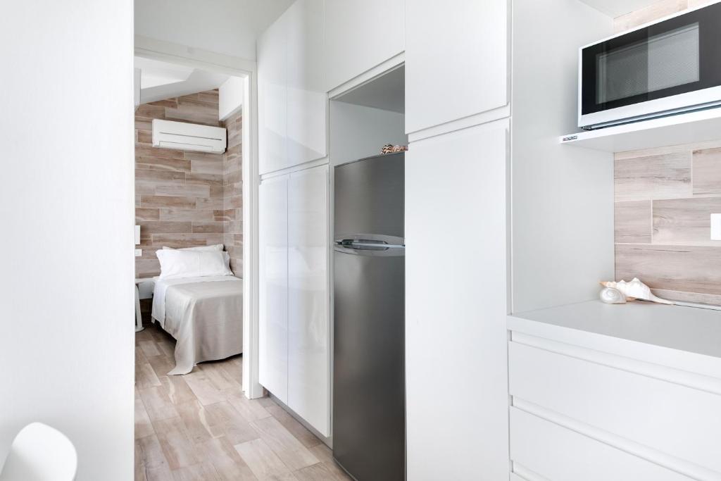 une petite cuisine avec un réfrigérateur et une chambre dans l'établissement Residence Diffuso Arcobaleno, à Gabicce Mare 190 autres photos