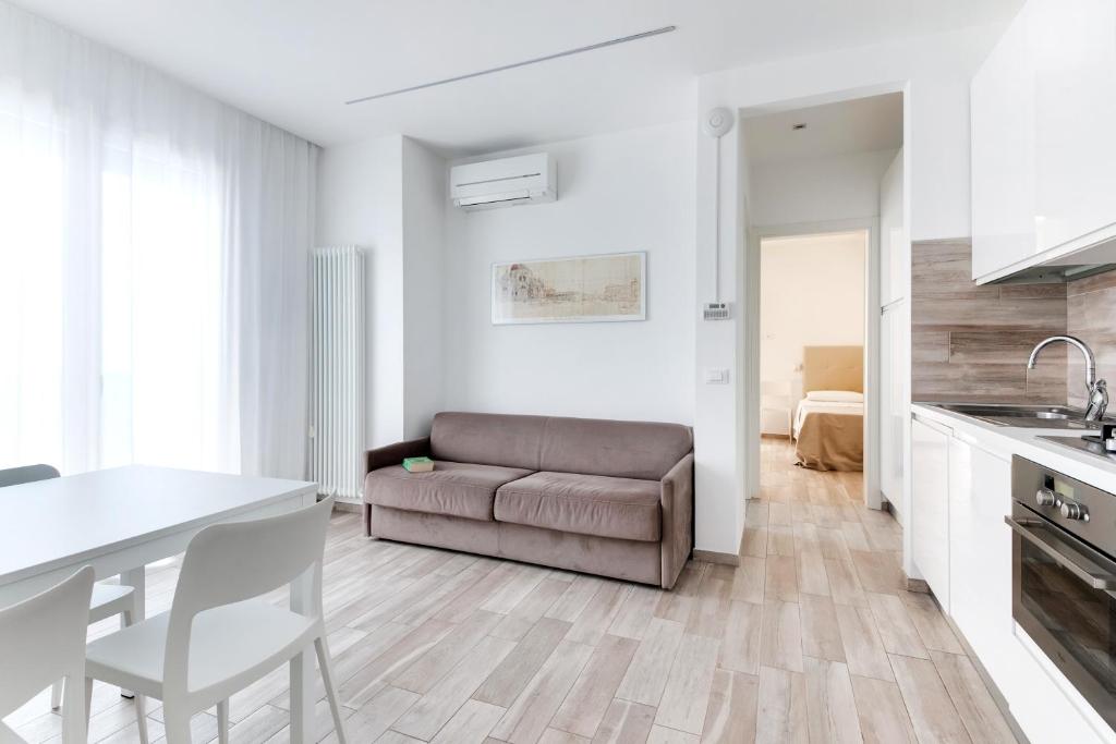 une cuisine et un salon avec un canapé et une table dans l'établissement Residence Diffuso Arcobaleno, à Gabicce Mare