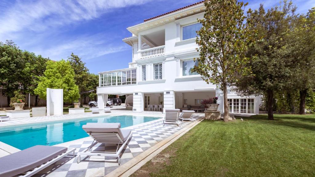 une maison blanche avec piscine et pelouse dans l'établissement VILLA LA PERLA BIANCA 10, Emma Villas, à Empoli