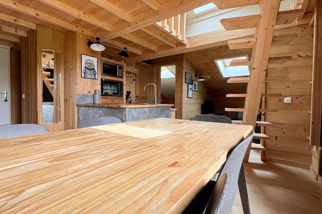 une salle à manger avec une table et des chaises en bois dans l'établissement T2 with pool in Saint-Gervais-les-Bains, à Saint-Gervais-les-Bains