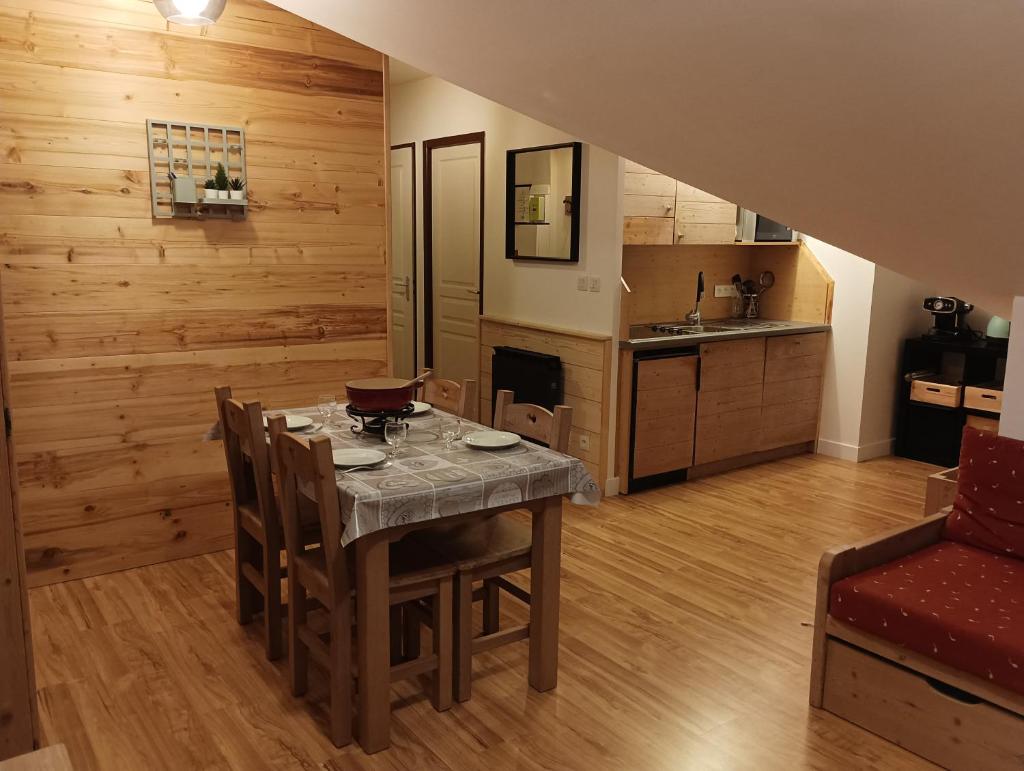 une cuisine et une salle à manger avec une table et des chaises dans l'établissement Studio Villar d'Arene Résidence la Meije Blanche, à Villar-dʼArêne