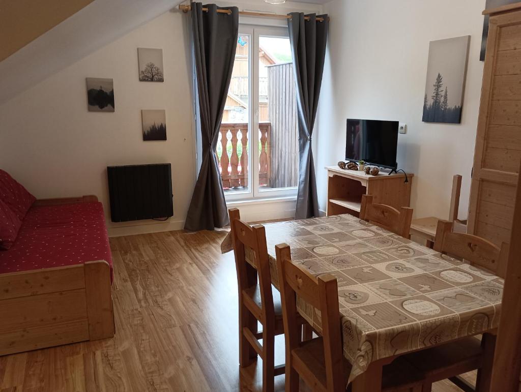 un salon avec une table à manger et une télévision dans l'établissement Studio Villar d'Arene Résidence la Meije Blanche, à Villar-dʼArêne