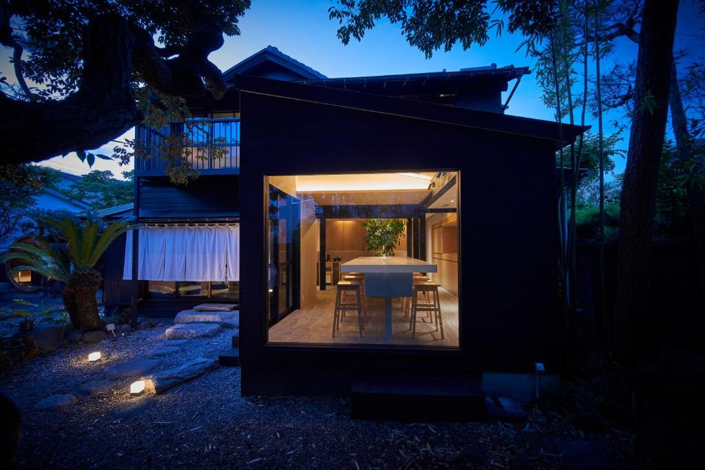 une petite maison noire avec une table et des chaises dans l'établissement AKAMA Kamakura, à Kamakura
